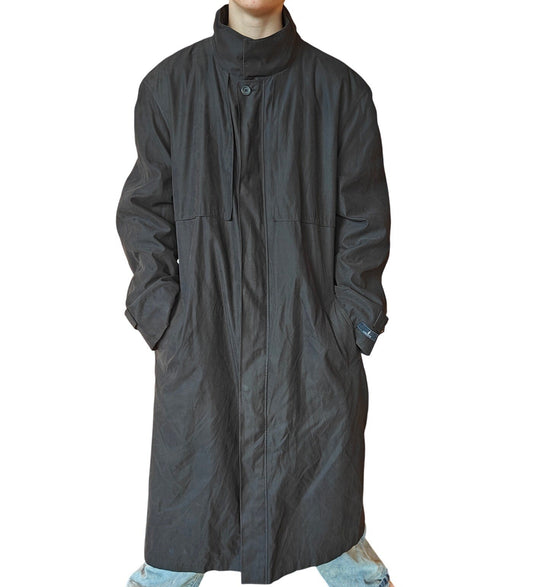 Long dark coat worn by a person on a white background